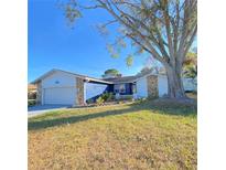 Charming single-story home featuring a well-maintained lawn, stone accents, and an attached garage at 3709 Feather Dr, Lakeland, FL 33812