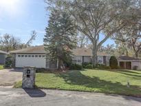 House exterior featuring a two-car garage and a well-manicured lawn at 3940 Laurel Branch Dr, Lakeland, FL 33810