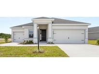 Charming single-Gathering home featuring a well-manicured lawn, a two-car garage, and a welcoming front entrance at 565 Sw 77Th Cir, Ocala, FL 34474