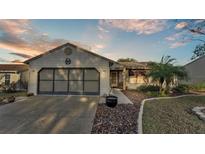 Tan one-story house with a two-car garage and landscaped yard at 6069 Kittiwake Dr, Lakeland, FL 33809
