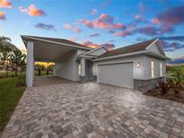 Single-story home with attached garage and paver driveway at 234 Laynewade Rd, Polk City, FL 33868