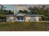 Newly renovated duplex with two blue doors and a well-manicured lawn at 1125 Josephine St, Lakeland, FL 33815