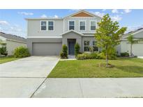 Two-story house with gray siding, two-car garage, and landscaped lawn at 1646 Seth Dr, Winter Haven, FL 33880