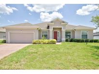 One-story home with attached garage and landscaped lawn at 317 Lake Mariana Way, Auburndale, FL 33823