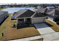 Charming single-story home with a well-manicured lawn and an attached two-car garage by the waterfront at 4018 Sundance Place Loop, Mulberry, FL 33860