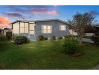Nice, well-maintained manufactured home with a screened porch and landscaped lawn at 5079 Lodgewood Dr, Lakeland, FL 33810