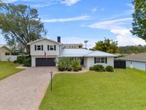 Stunning two-story home with a landscaped lawn and brick driveway at 55 Lake Link Se Cir, Winter Haven, FL 33884