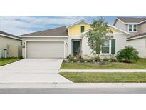 House exterior featuring a two-car garage and well-maintained lawn at 636 Trotters Dr, Eagle Lake, FL 33839