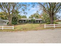 Ranch style home with mature landscaping and white picket fence at 1628 Lakewood S Dr, Lakeland, FL 33813