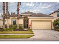 One-story house with beige walls, a two-car garage, and lush landscaping at 2507 Torrens Dr, Lakeland, FL 33805