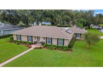 Ranch-style home with landscaped yard and solar panels at 2620 Jonila Ave, Lakeland, FL 33803