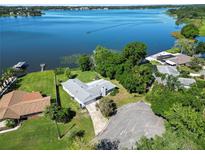 Aerial view of a single-story home on the lake, with a large backyard and boat access at 5252 Post Ln, Lakeland, FL 33809