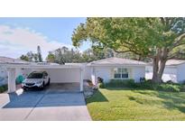 Front view of charming single story home with carport and mature landscaping at 646 Cottage Ln, Lakeland, FL 33803