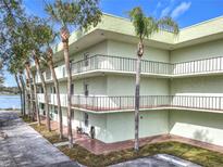 Inviting condo complex featuring multiple balconies, lush landscaping, and tranquil waterfront views at 1130 N Lake Parker Ave # A306, Lakeland, FL 33805