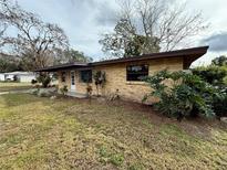 Brick ranch home with a landscaped yard and driveway at 122 8Th Se St, Fort Meade, FL 33841