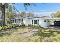 White house with carport, landscaping, and a spacious yard at 1317 W Belmar St, Lakeland, FL 33815