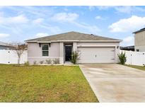 One-story house with a two-car garage and landscaped yard at 1405 Kissimmee Dr, Kissimmee, FL 34759