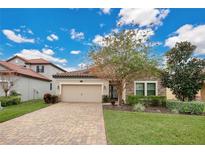 One-story home with stone accents, a paved driveway, and landscaped lawn at 1832 Prima Vista Dr, Lakeland, FL 33810