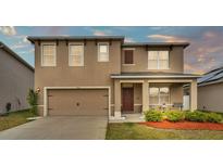 Two-story house with tan siding, brown roof and landscaping at 1915 Pristine Loop, Lakeland, FL 33811