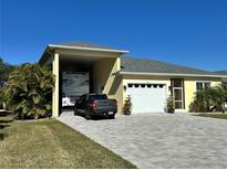 House exterior showcasing RV garage, paved driveway, and landscaping at 593 Meandering Way, Polk City, FL 33868