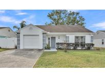 White one-story house with gray accents, attached garage, and well-maintained lawn at 6111 Morningview Dr, Lakeland, FL 33813