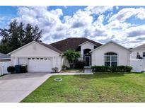 House exterior featuring a two-car garage and well-maintained lawn at 8 Sawfish Ln, Kissimmee, FL 34759