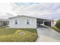 Well-maintained manufactured home with carport and landscaped lawn at 1801 Quail Hill Dr, Lakeland, FL 33810