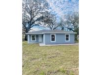 Newly constructed home with gray siding and a well-manicured lawn at 2006 Kendrick Ln, Lakeland, FL 33805