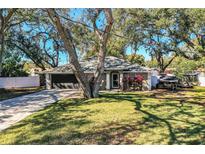 Single-story home with a gray exterior, attached garage, and lush lawn at 2227 Howard West Ave, Winter Haven, FL 33880