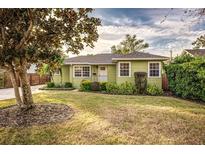 Charming light green house with well-manicured lawn and mature trees at 2729 Woodland Hills Ave, Lakeland, FL 33803