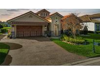 Brick paver driveway leads to a charming two-story home with a large garage at 2961 Sanctuary Cir, Lakeland, FL 33803