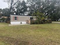 Mobile home with a spacious yard and wooden deck at 3472 Avenue V Nw, Winter Haven, FL 33881