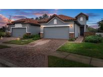 Two-story home with gray exterior, tile roof, and brick paver driveway at 4108 Solamor St, Lakeland, FL 33810