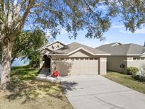 House exterior showcasing a two-car garage and landscaped yard at 4481 Pebble Pointe Dr, Lakeland, FL 33813