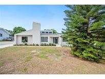 Charming single-story home with a light-colored exterior, a black front door, and tidy landscaping at 4718 Valley Hill Ct, Lakeland, FL 33813