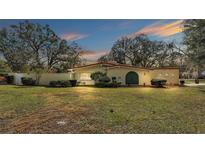 Ranch style home with large green door and mature trees at 513 E Highland Dr, Lakeland, FL 33813