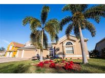 Beautiful home with palm trees and well-manicured lawn at 518 Grand Reserve Dr, Davenport, FL 33837