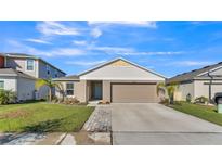 Single-story home with a two-car garage and landscaped lawn at 5440 Siltstone St, Lakeland, FL 33811