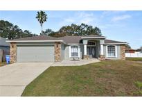 Charming one-story house with a two-car garage and landscaped lawn at 5819 Driftwood Dr, Winter Haven, FL 33884