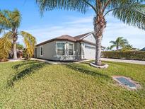 Single-story home with gray exterior, two-car garage, and palm trees at 5876 Great Salt Ct, Lakeland, FL 33805