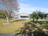 Single-wide manufactured home with carport and landscaped yard at 6087 Southern Oaks Se Dr, Winter Haven, FL 33884