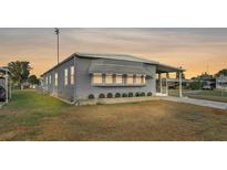 Gray single-wide manufactured home with landscaped lawn and screened porch at 1610 Reynolds Rd # 236, Lakeland, FL 33801