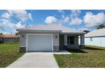 Charming single-story home with a gray exterior, well-manicured lawn, and attached garage at 2013 Alderman Rd, Auburndale, FL 33823