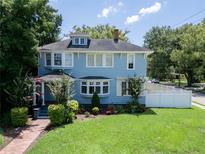 Charming blue two-story home with lush green lawn, brick walkway, and beautiful landscaping at 2016 Seminole Trl, Lakeland, FL 33803