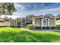 House exterior features a light brown color, manicured lawn, and walkway at 3116 Hawks Ridge Dr, Lakeland, FL 33810