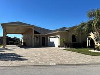 House exterior showcasing a paver driveway and landscaping at 516 Homecoming Way, Polk City, FL 33868