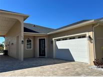 Two-story house with covered carport and paver driveway at 516 Homecoming Way, Polk City, FL 33868