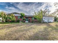 Brick ranch home with green door, mature landscaping, and spacious yard at 518 Boger N Blvd, Lakeland, FL 33803