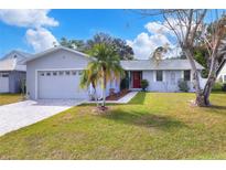 Updated one-story home features a gray exterior, red door, and a well-manicured lawn at 813 Heron Pl, Winter Haven, FL 33884