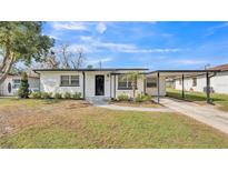 Charming single-story home featuring a well-manicured lawn and inviting covered carport at 1038 Canal E Dr, Lakeland, FL 33801